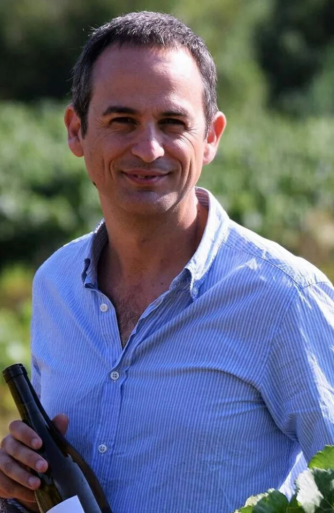 Álvaro González Marco a la vinya amb una ampolla de vi
